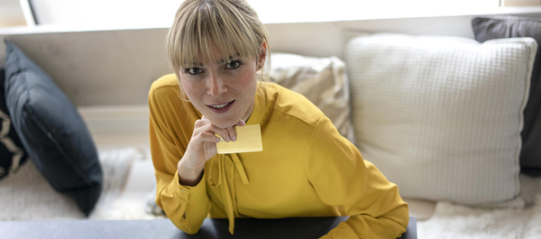 Eine Frau mit gelber Bluse und einer Karte