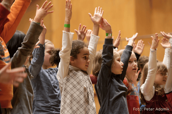 SING!-Kinder beim Singen mit nach oben gestreckten Armen
