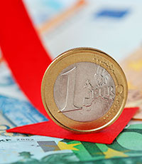 Eine Euro-Münze steht auf einem roten Pfeil, im Hintergrund sind Euro-Scheine ersichtlich.
