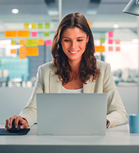 Eine Büroangestellte sitzt vor einem Laptop. Foto: Gorodenkoff/Shutterstock.com.