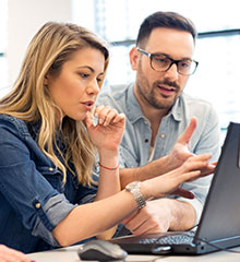 Eine Frau und ein Mann arbeiten an einem Laptop. Foto: zorandim75/stock.adobe.com.
