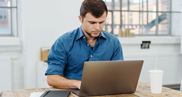 Ein Mann arbeitet am Laptop. Foto: stockfour/Shutterstock.com.