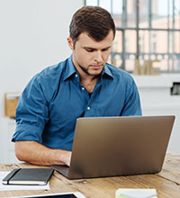 Ein Mann arbeitet am Laptop. Foto: stockfour/Shutterstock.com.