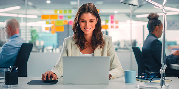 Eine Büroangestellte sitzt vor einem Laptop. Foto: Gorodenkoff/Shutterstock.com.