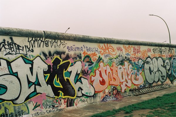 Part of the Berlin Wall with colourful graffiti.