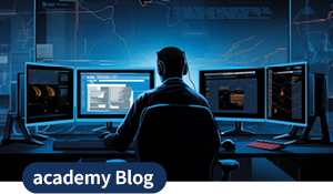Eine Person an mehreren Monitoren in einer dunklen IT-Umgebung