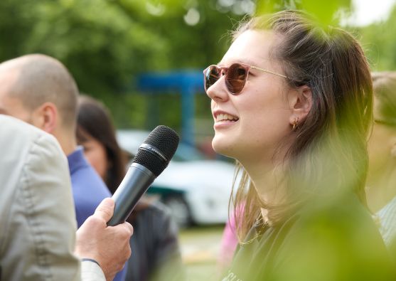 Neben einer Person mit Laptop liegen Broschüren auf einer Bank. Die Aufschrift "Wer sich bewegt, bewegt Europa!" ist zu erkennen.