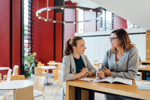 Eine Gruppe junger Erwachsener steht auf einer Bühne und applaudiert gemeinsam mit dem Publikum. Hinter der Bühne ist auf einer Leinweinwand ein Leuchtturm und der Schriftzug "Science Show" zu erkennen.