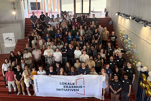 Gruppenfoto aller Teilnehmenden des LEI-Jahresstreffens in Stuttgart. Sie halten verschiedene Fahnen von Lokalen Erasmus+ Initiativen in den Händen.